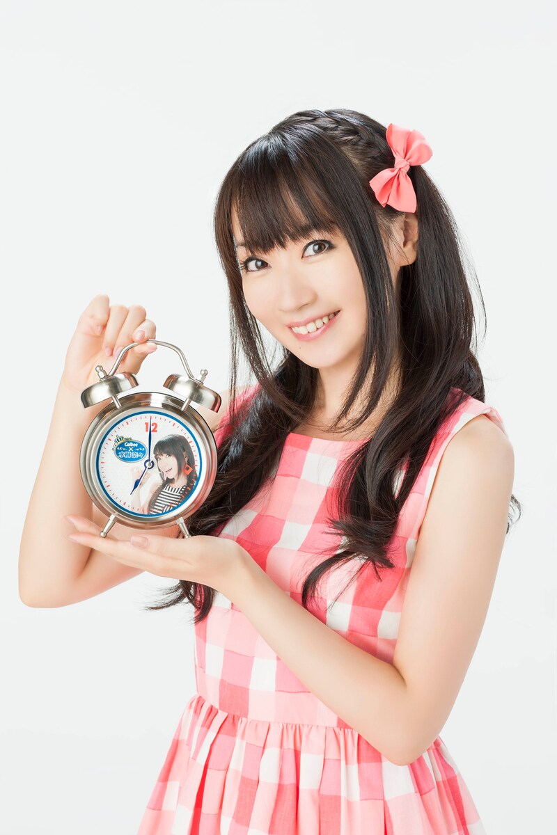 「水樹奈々 ボイス目覚まし時計」を手にする水樹奈々。