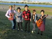 土手に集まったグレートマエカワ、鈴木圭介、大槻ケンヂ、ハルカトミユキ（左から）。