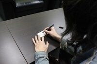 「the dresscodes "1" ENTRY CARD」にサインを書く志磨遼平。