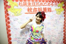 フラッグを前にピースする秋本帆華。