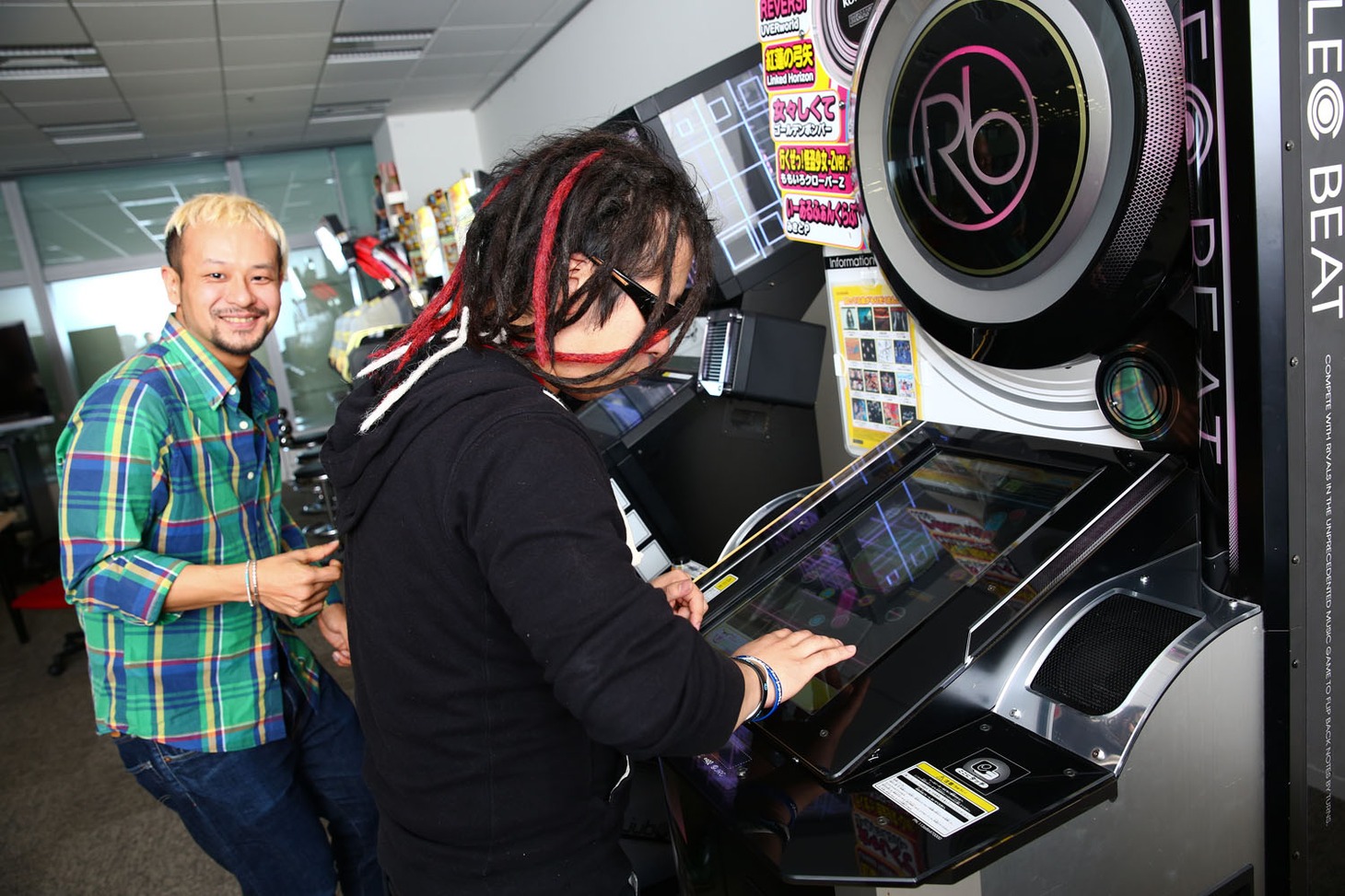 「REFLEC BEAT groovin'!! Upper」をプレイするHIRO（手前）と、リズムに合わせて“指パッチン”をするHAYATO（奥）。