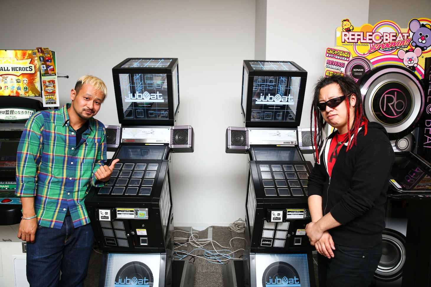 「jubeat saucer fulfill」筐体の前で記念撮影をするHAYATO、HIRO（左から）。