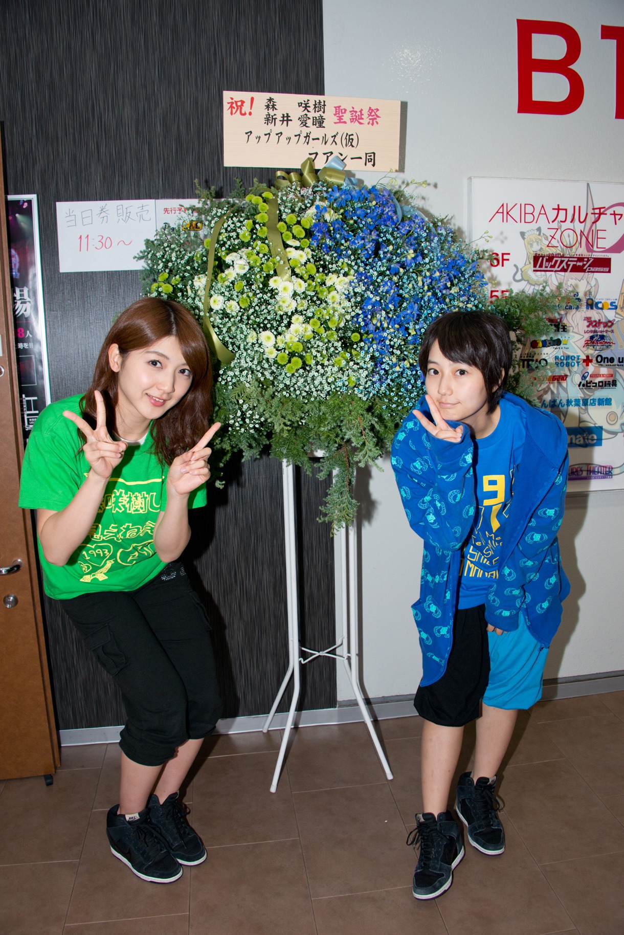 生誕祭のお祝いの花を前に記念撮影する森咲樹、新井愛瞳。