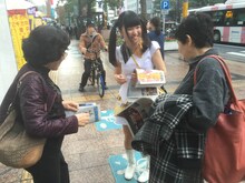 西鉄福岡駅駅前にて号外を配布する伊藤麻希。