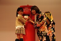 子供の年賀状投函をサポートする橋本奈々未（右）。
