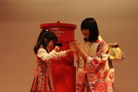 子供の年賀状投函をサポートする生田絵梨花（右）。