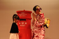 子供の年賀状投函をサポートする西野七瀬（右）。