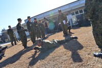 匍匐前進の説明を受けるアップアップガールズ（仮）。