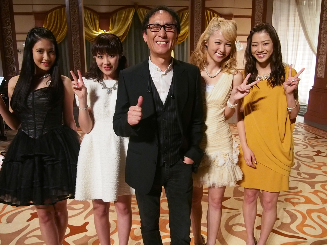 E-girlsメンバーと記念撮影する武部聡志音楽監督（中央）。