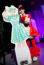 坂本遥奈のパネルを抱えながら歌う秋本帆華。