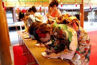 絵馬に願い事を書きこむ新成人メンバー。