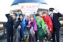 「リゾート ドルフィン号」の前で記念撮影する超特急。