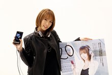 「ウォークマンぴあ」誌のパネルを前にソニー「NW-ZX2」を手にする藍井エイル