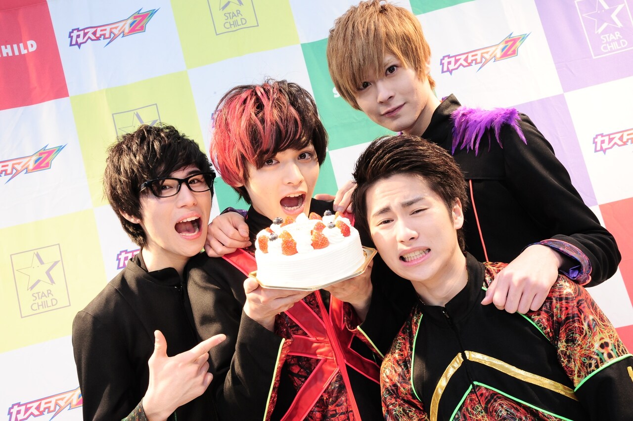 ケーキを持つGORO（Vo, G）を囲むHIROKI（B）、DAICHI（Dr）、HAMA（Vo）。