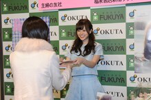 ファンにフォトブックを手渡す白石麻衣（乃木坂46）。