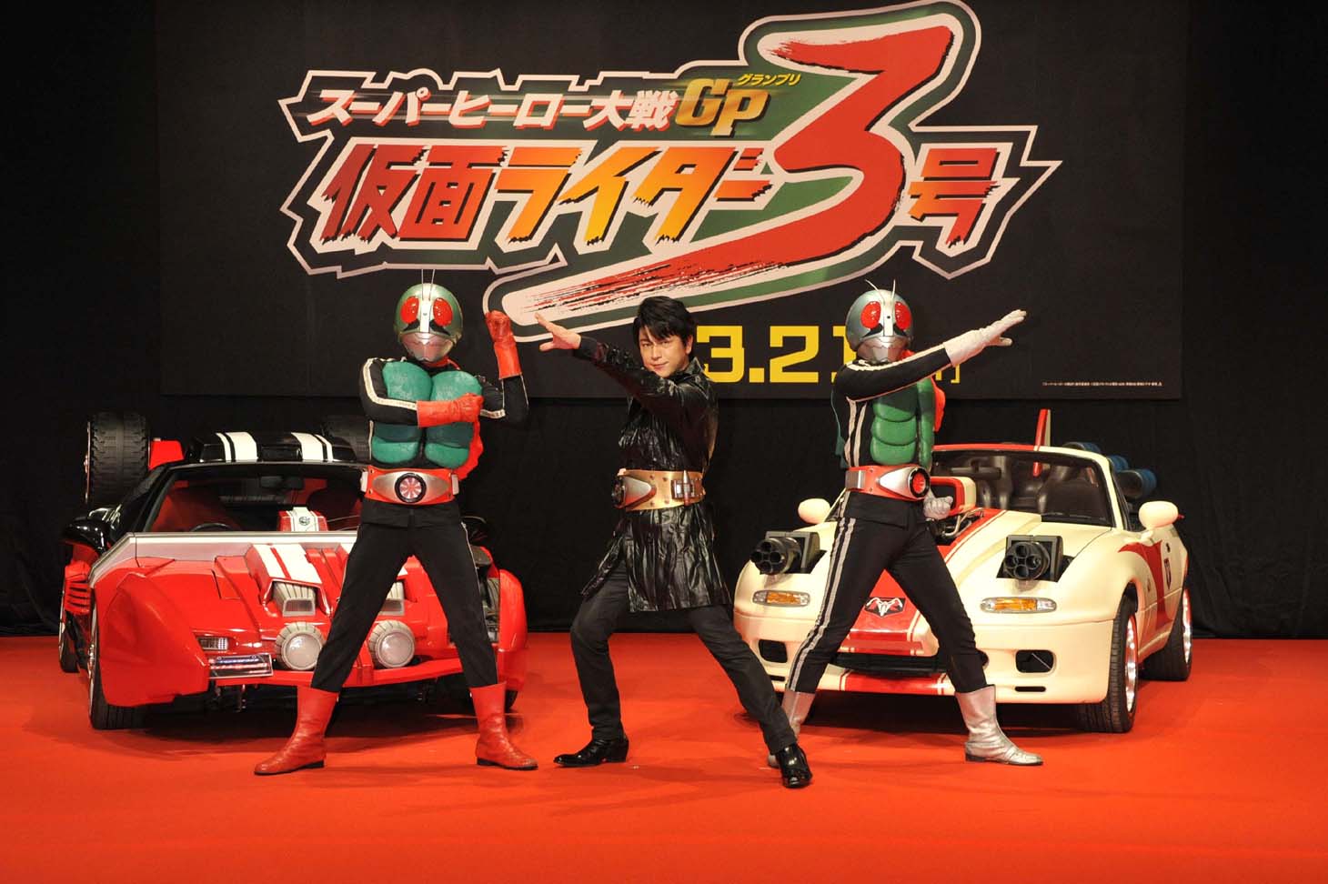 変身ポーズを披露する及川光博。左は仮面ライダー2号、右は仮面ライダー1号。