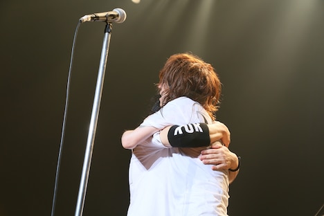 強く抱きしめ合う清春と人時。（撮影：今井俊彦、森好弘）