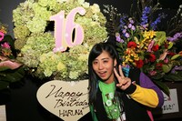 ファンからの“手羽先キミドリ”色のスタンド花を前にピースする坂本遥奈。