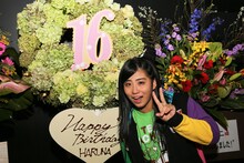 ファンからの“手羽先キミドリ”色のスタンド花を前にピースする坂本遥奈。