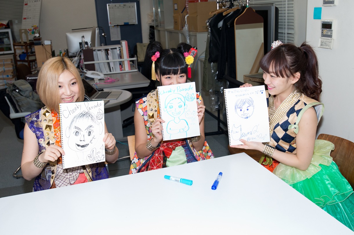 PRキャラバン先の担当者の似顔絵描き対決を行う鈴木真梨耶、溝呂木世蘭、関根優那。
