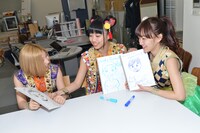 PRキャラバン先の担当者の似顔絵描き対決を行う鈴木真梨耶、溝呂木世蘭、関根優那。