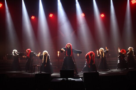 「総決起集会」の幕開けを飾った般若面のダンサーたち。