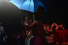 傘を差してフロアを歩くもも。