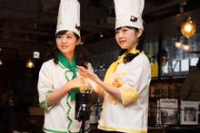 待ち時間に撮影用の照明で暖を取る菊地最愛と水野由結。