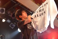 ファンからプレゼントされたパーカーを掲げるGOMESS。