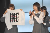 若月佑美がオリジナルグッズを説明する様子。
