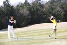 伊藤千由李（右）のフォームを確認する武市悦宏プロ（左）。