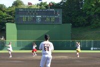 大きく振りかぶる長谷川愛里投手、其原有沙投手、田尻あやめ投手（左から）。バックスクリーンには投手6人の名前が。