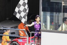 チェッカーフラッグを振る大黒柚姫。