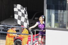 チェッカーフラッグを振る大黒柚姫。