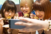 お好み焼きを食べる姿を自撮りする、まなみのりさ。