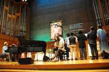 羊毛とおはな「千葉はな お別れ会」にて、千葉はな（Vo）の写真の前で楽曲を披露する羊毛こと市川和則（G）とライブのサポートメンバー、大橋トリオ、コトリンゴ。