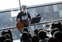 弾き語りを行う坂詰克彦。（写真提供：テイチクエンタテインメント）