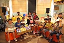 ワークショップ「オリジナル楽器をつくってミュージシャンと演奏しよう！」に参加したU-zhaan（後列中央）。