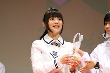 新玉ねぎを配る上坂すみれ。