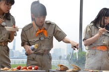 ホタテを焼く真山りか（中央）。