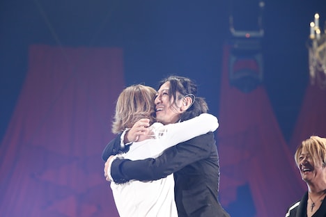 抱きしめあうYOSHIKIとTAKURO（G）。（撮影：岡田裕介）