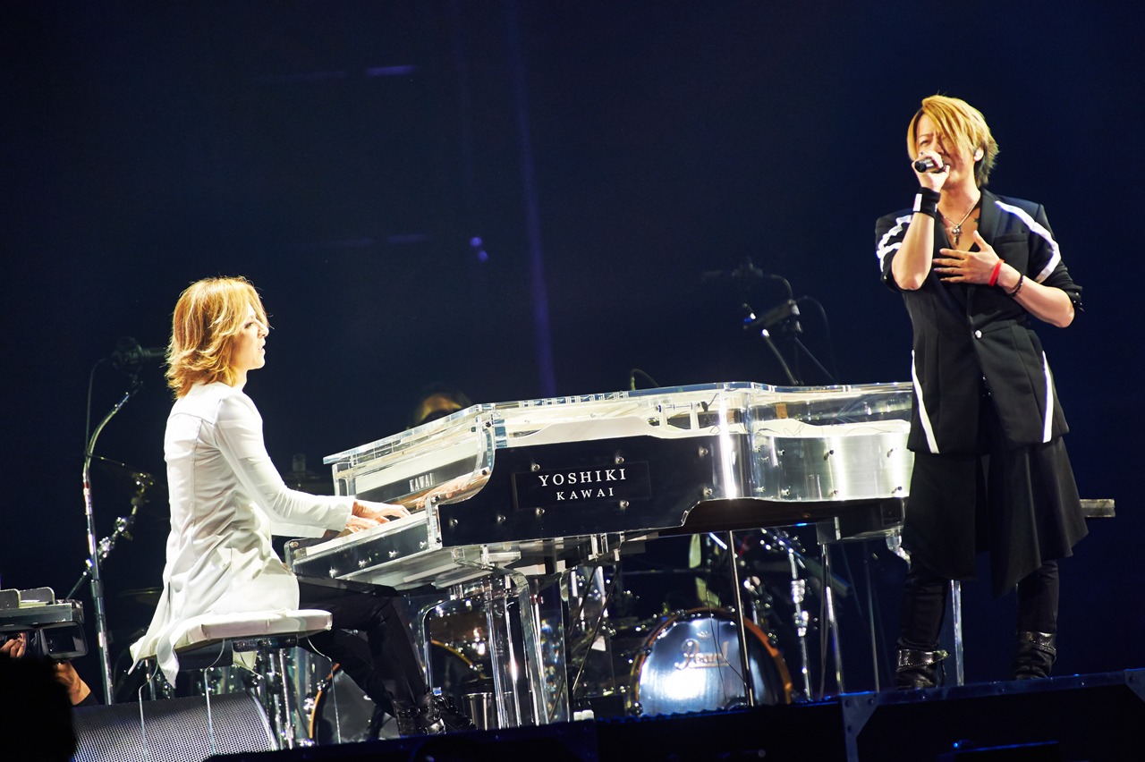 今週の人気画像8位は「YOSHIKI、GLAYメンバーと熱い抱擁！ドームで後輩の20周年を祝福」より、写真左より、「RAIN」を奏でるYOSHIKI（X JAPAN）と熱唱するTERU（GLAY）。（撮影：岡田裕介）