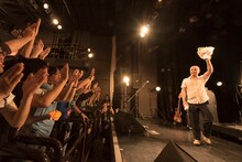 アンコールを終え、ファンからもらった花束を掲げながらステージを去る二宮友和。（撮影：平川啓子）