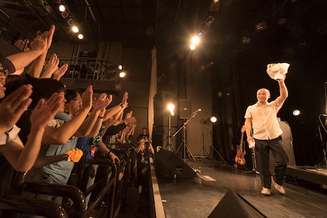 アンコールを終え、ファンからもらった花束を掲げながらステージを去る二宮友和。（撮影：平川啓子）