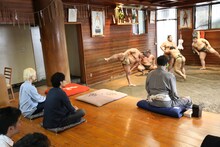 力士たちの稽古を見学する吉田山田。（提供：ポニーキャニオン）