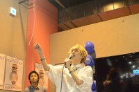 不安そうに垂れ幕の紐に手を伸ばすこんどうようぢ。