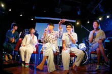 写真左よりちばぎん（B）、みさこ（Dr）、の子（Vo, G）、mono（Key）、司会を務めた大山卓也（ナタリー）。（写真提供：ワーナーミュージック・ジャパン）