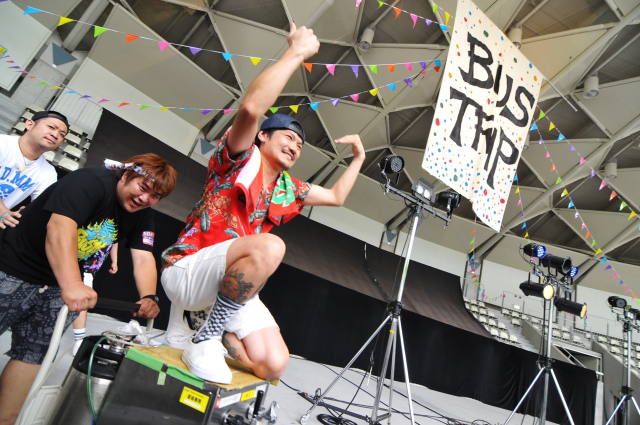 ビールサーバーに乗って登場するSATOBOY（B, Vo / SUNSET BUS）。（Photo by rockey）