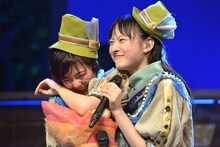 「私立恵比寿中学 飛び出せ全十ホールツアー2015～わっくわくはるバルーンGOGO～」追加公演の様子。安本彩花（左）を抱きしめながら歌う松野莉奈（右）。