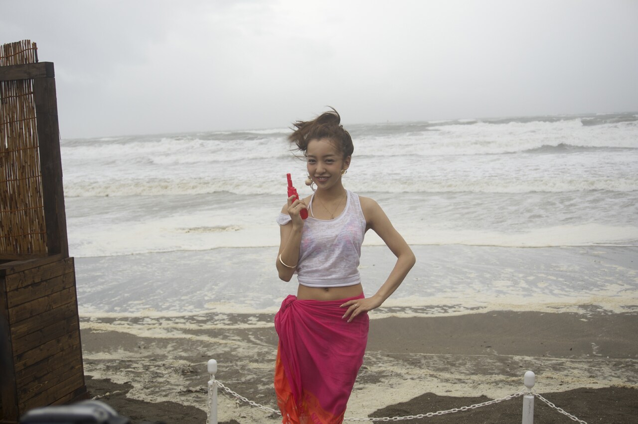 大荒れの由比ケ浜をバックに笑顔の板野友美。（写真提供：キングレコード）